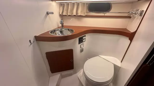 Compact bathroom in 2008 Nimbus 42 Nova yacht with sink, toilet, and wooden accents.