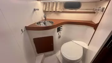 Compact bathroom in 2008 Nimbus 42 Nova yacht with sink, toilet, and wooden accents.