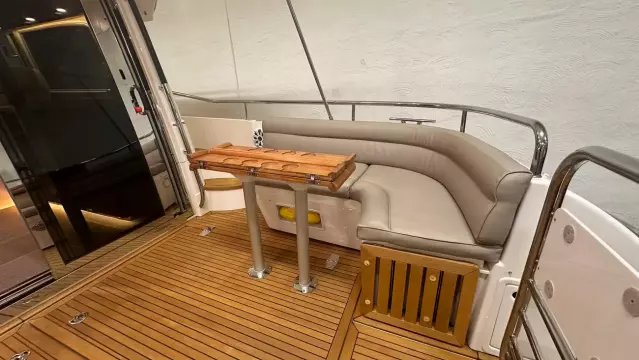 Luxurious seating area on 2008 Nimbus 42 Nova yacht with wooden deck and table.