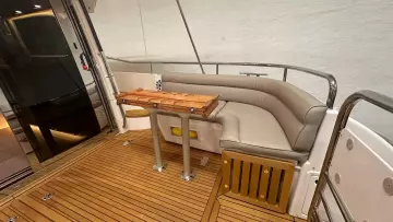Luxurious seating area on 2008 Nimbus 42 Nova yacht with wooden deck and table.