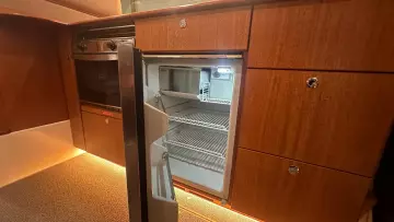 Wooden kitchen interior with open fridge in 2008 Nimbus 42 Nova boat.
