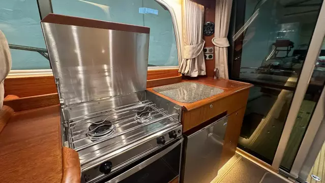 Compact kitchen area in a 2008 Nimbus 42 Nova boat with stove and sink.