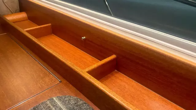 Wooden interior detail of a 2008 Nimbus 42 Nova boat, showcasing storage compartments.