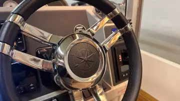 Steering wheel of a 2008 Nimbus 42 Nova boat, featuring a compass emblem.