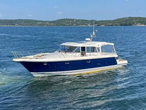 2008 Nimbus 42 Nova yacht cruising on a serene blue sea with distant green hills.