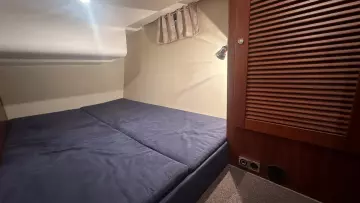 Cozy cabin interior of 2008 Nimbus 42 Nova with blue bedding and wooden accents.