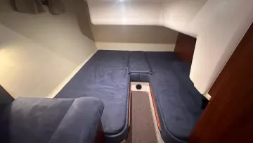 Cozy interior cabin of 2008 Nimbus 42 Nova with blue seating and wooden accents.